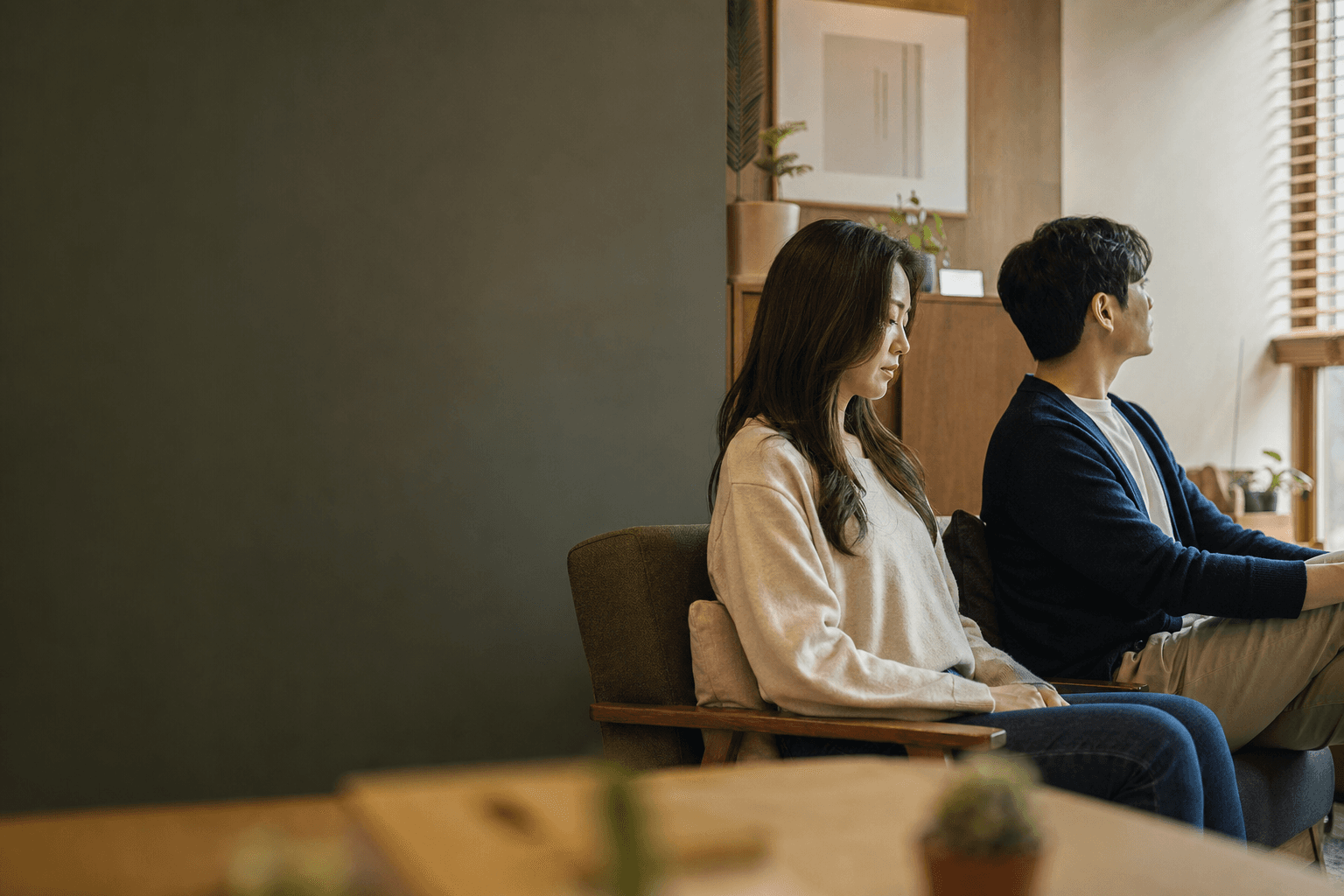 상담실 소파에 나란히 앉아 각자 다른 곳을 보는 부부
